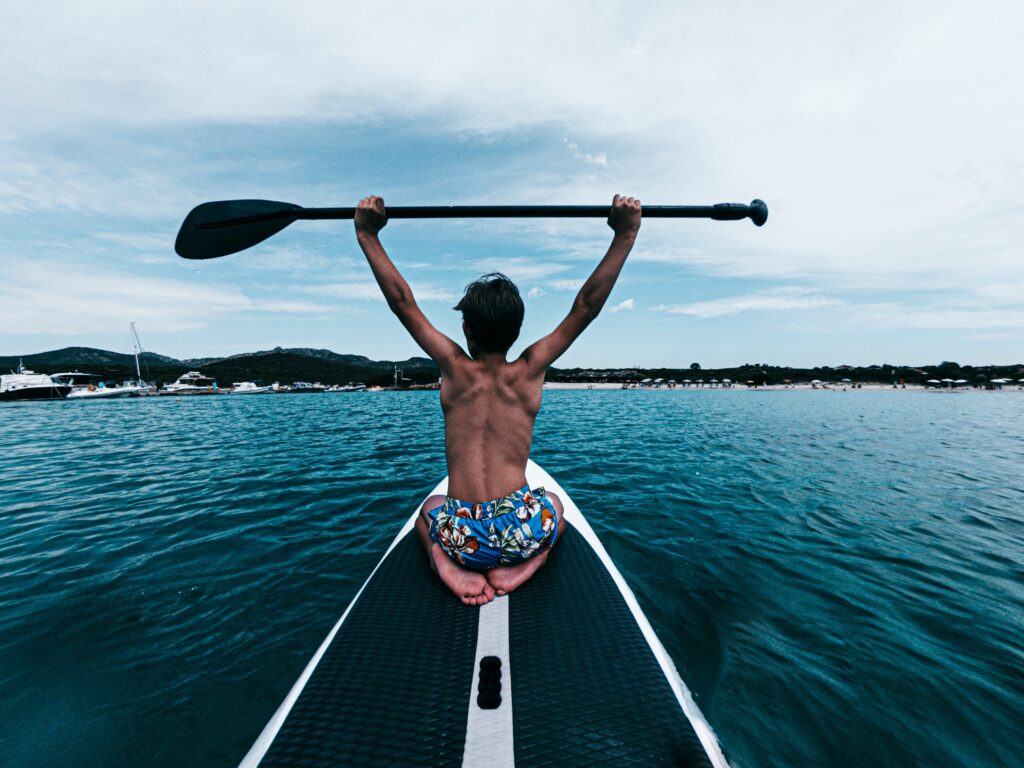 Mann auf einem Stand Up Paddler Board oder SUP Board, Symbolbild für die Erläuterung, wieviel ein SUP Board kostet und was die SUP Board Kosten sind.