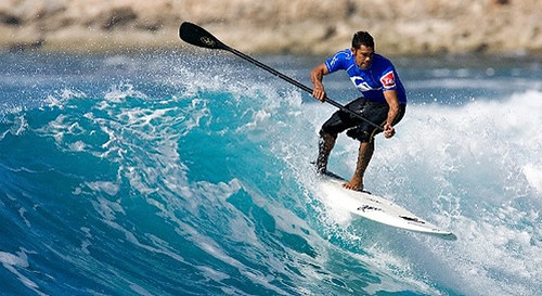 Stand Up Paddles riding a wave and using the Surf Stance on the SUP Board. Photo by by Elixirboardco