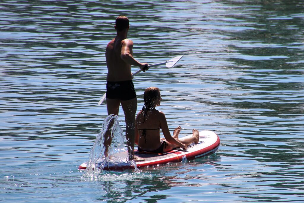 Paar beim Stand Up Paddling auf einem See Mann und Frau beim stand up paddling oder paddleboarding