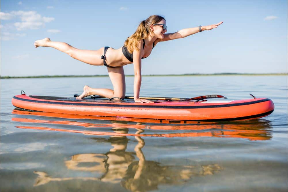 Young woman doing yoga on the paddleboard