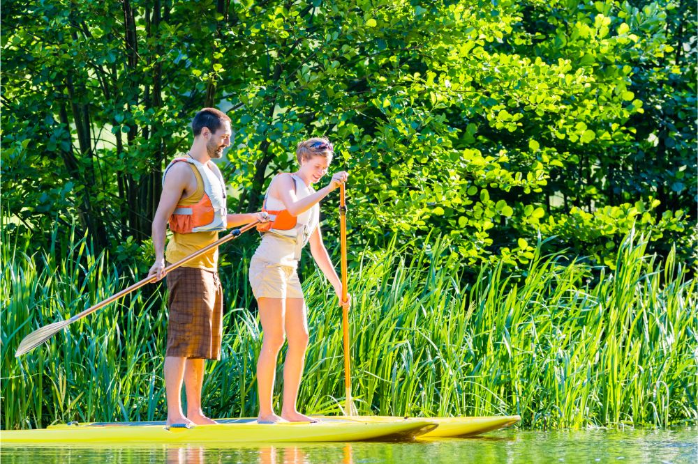 Frau auf einem Stand Up Paddleboard auf einem Fluss