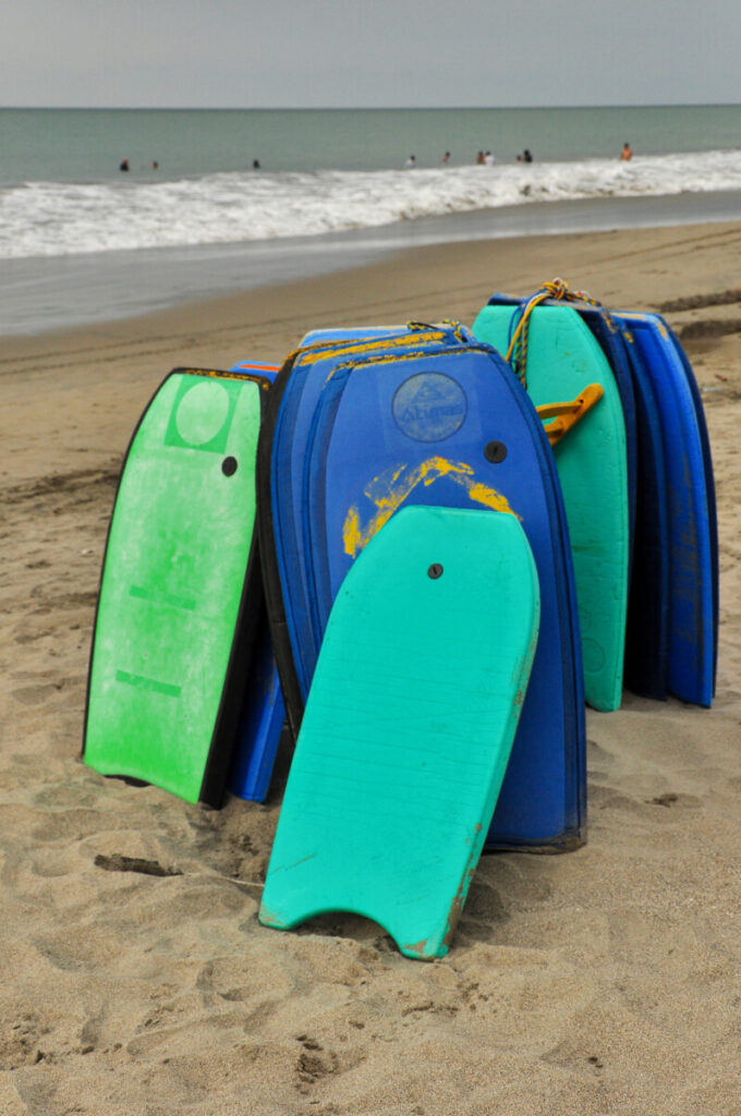 Bodyboard piled up at the beach, article about the right sizing of bodyboards giving a lot of tips on how to determine the correct size easily and correctly