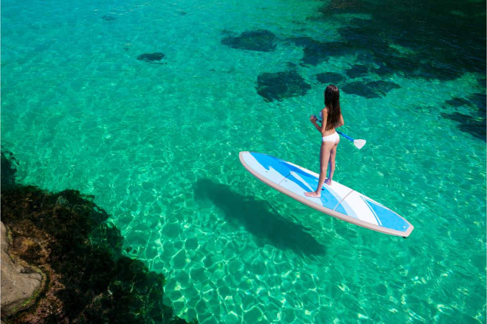 Young attractive woman in the sea on the Stand Up Paddle Board.