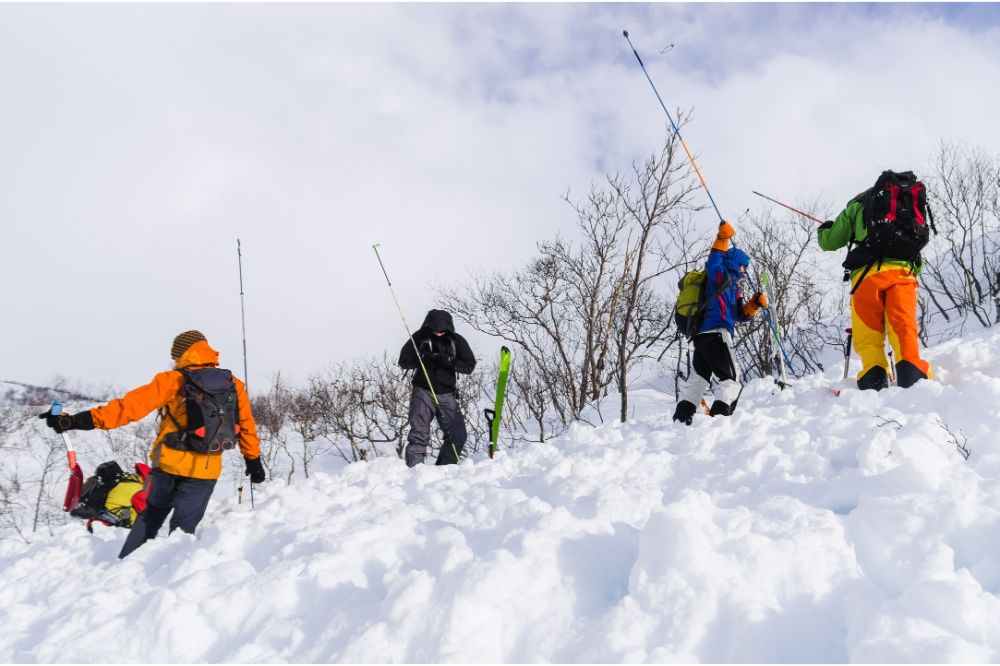 People training the usage of avlanche probes wearing avalanche airbags