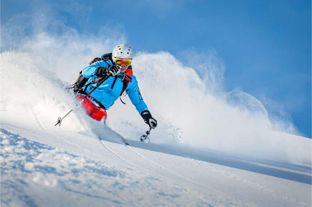 Male freeride skier in the mountains riding some deep powder snow