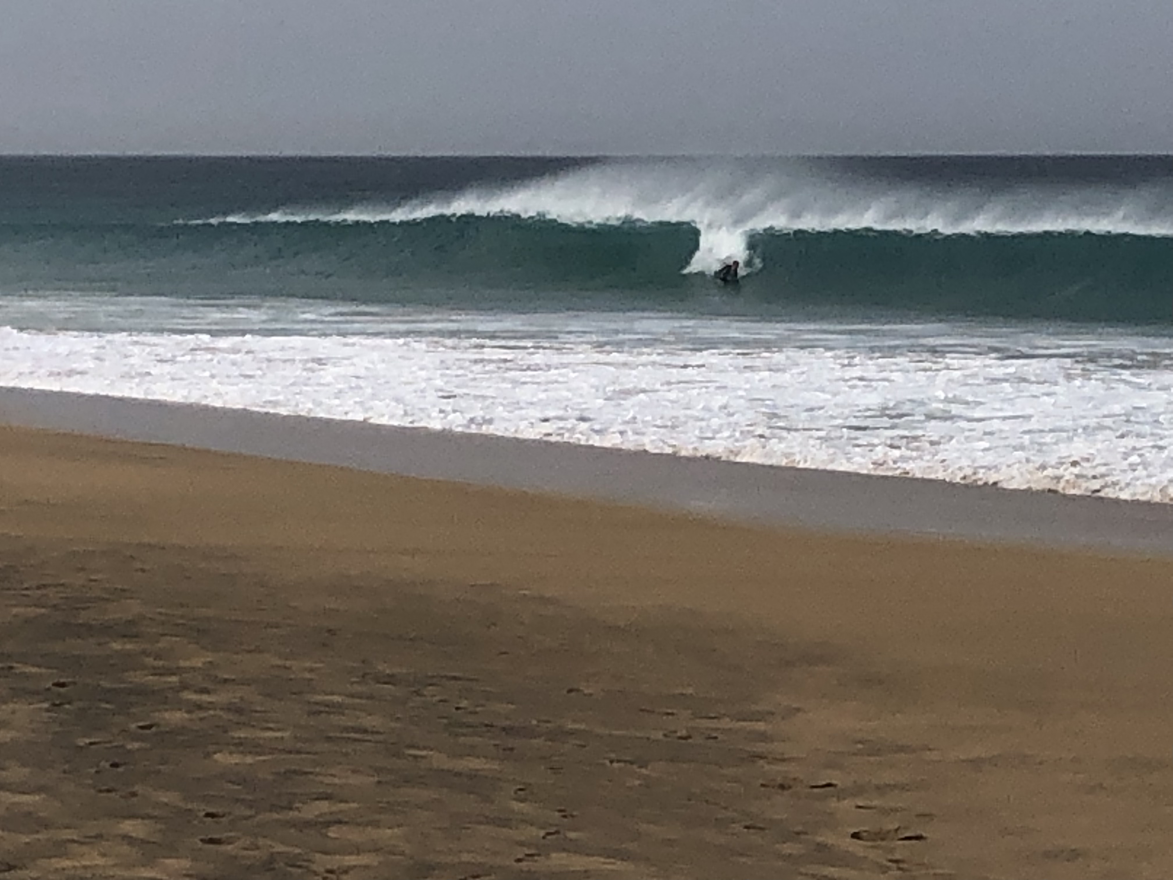 Bodyboarder or Boogie Boarder riding a wave from an article answering the question how big do waves need to be to Boogie Board