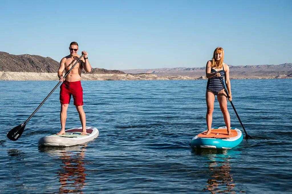 Coolwater Sports choice of the best inflatable Paddle Board under 500 by ROC. Man and woman doing Stand Up Paddle Boarding on a lake