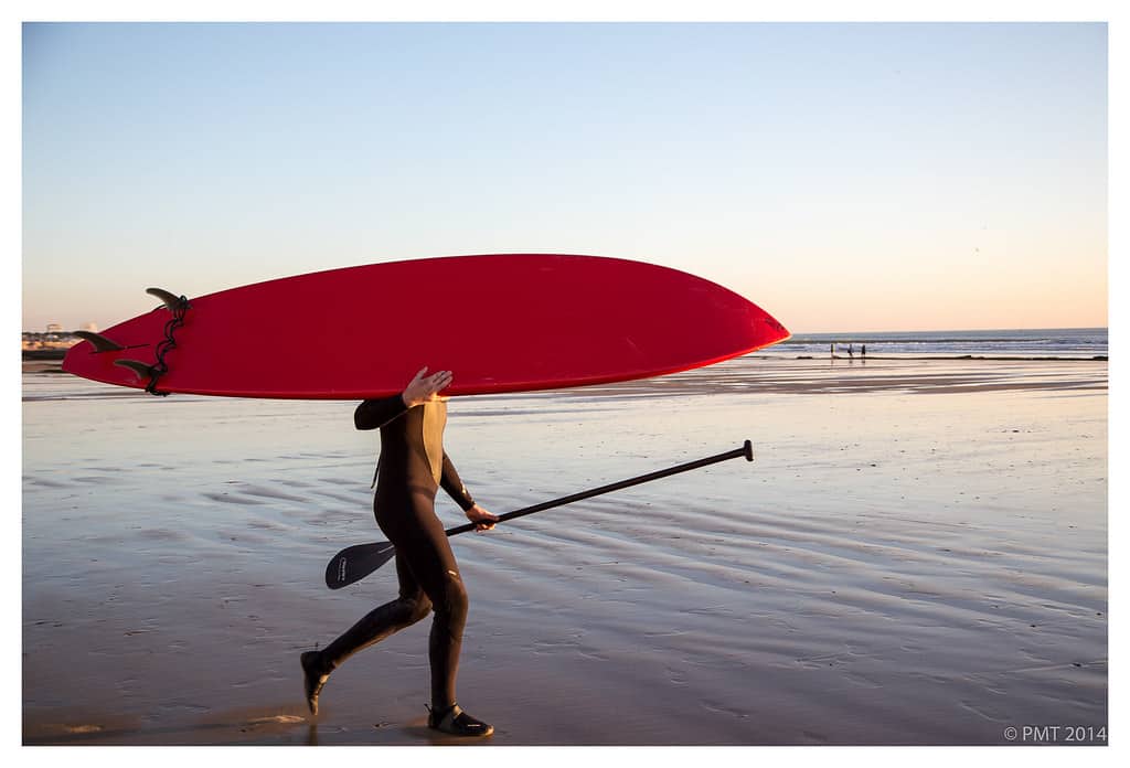 Man with a Stand Up Paddle Board walking on the beach towards the water. Photo by by philturp.
article on how to get up on a stand up paddle board