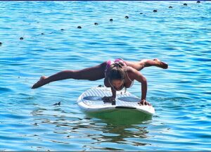 Frau welche Fitnessübungen auf einem Stand Up Paddle Board macht, SUP Freestyle by Karma Surf Retreat