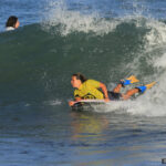 Woman riding a wave with a bodyboard wearing bodyboard fins