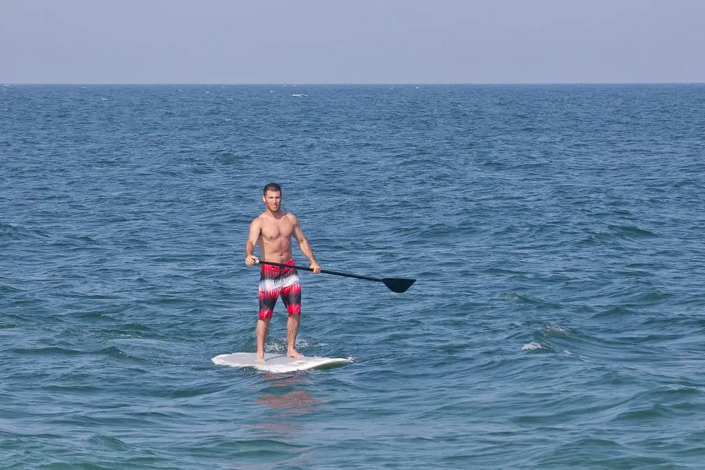 Paddleboarding, man on a Stand Up Paddleboard in an article about Paddle Board Turning Techique, picture by https://www.flickr.com/photos/36521958135@N01