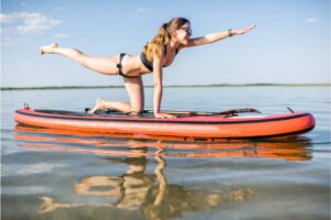 Young woman doing yoga on the paddleboard