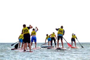 Group of people compete in rowing on stand up paddle board