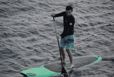 Man doing Touring Paddleboarding on a lake, man on a Touring SUP Board, Man on a Touring Stand Up Paddle Board used in an article explaing what is a Touring SUP Board