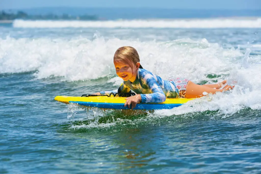 Kid on a Bodyboard wearing a Swim shirt
