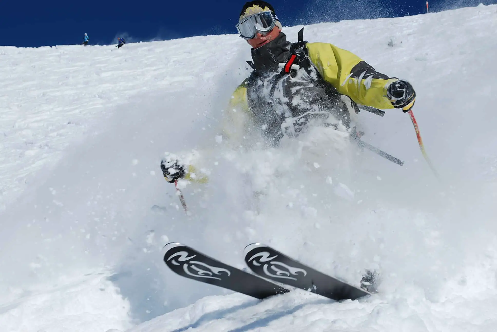 Freerider skiing deep powder, powder skiing, picture of a freerider in an article explaining the difference between freeriding, powder skiing, backcountry skiing and mounaineering