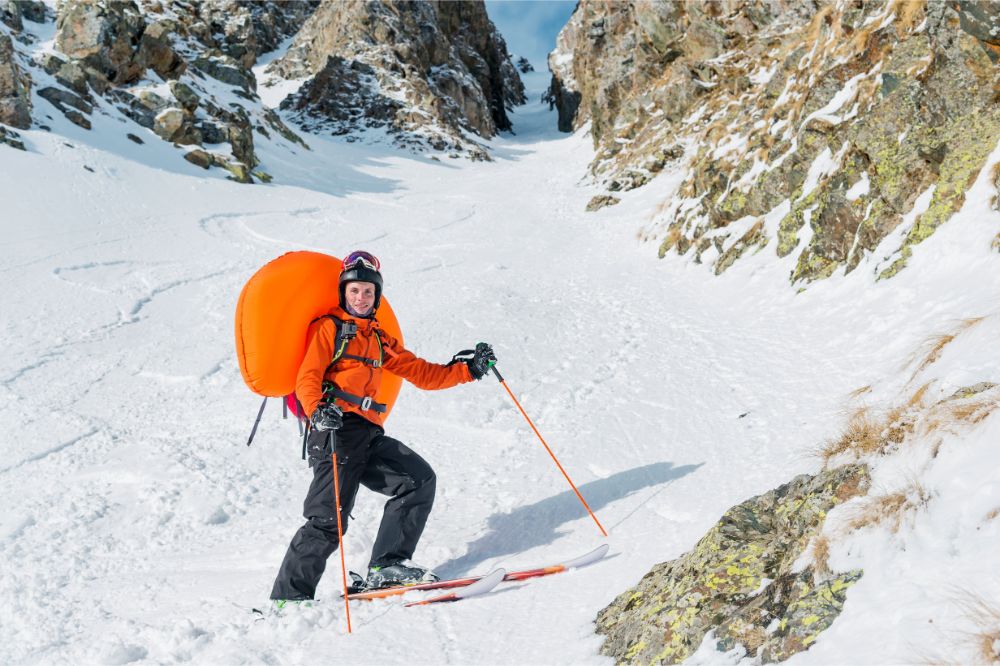  Glücklicher Freeride Skifahrer mit einem ausgelösten Lawinenairbag oder ABS Rucksack