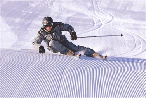 Mann der auf Carving Ski eine Kurve macht, Carving ist eine spezielle Art von Skifahren und Skitechnik