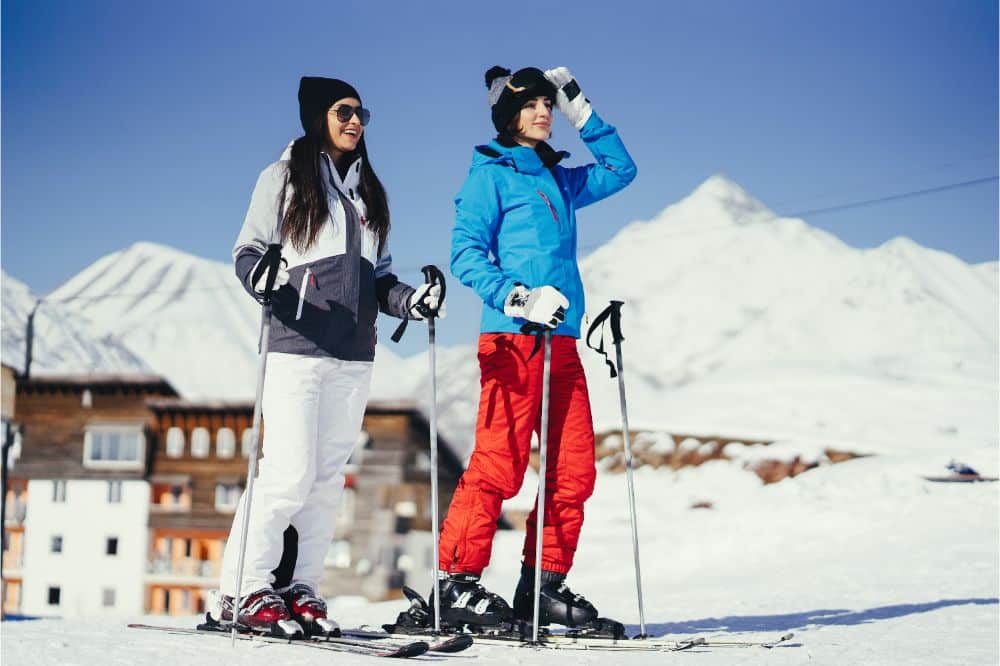 girls in winter clothing and skis as a winter sports mountain resort