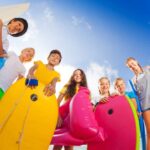 kids on beach with swimming and bodyboarding equipment