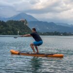 young man exercising on paddle board at the lake