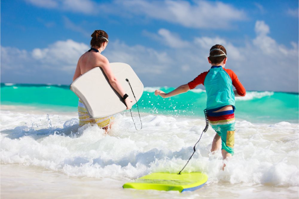 Mother and son with boogie boards used in an article explaining how to maintain and care for your bodyboard