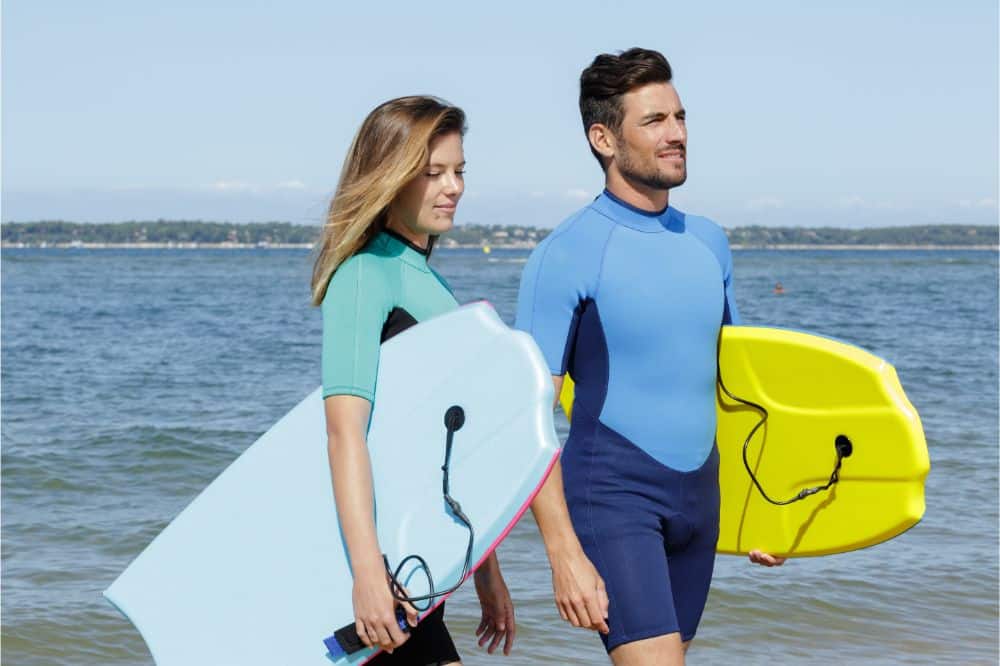 Couple holding their body board