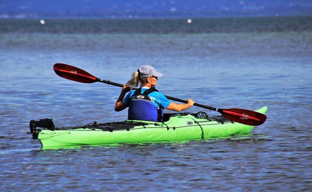 kayak, on the water, woman paddling on a lake in her kayak