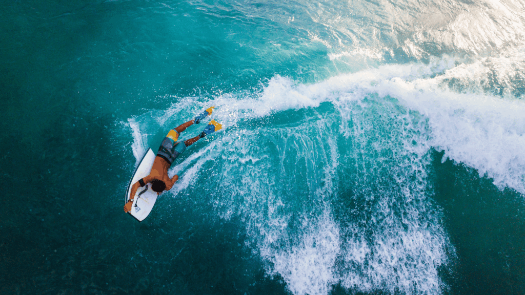A photo taken from above of a man on a bodyboard in the ocean,