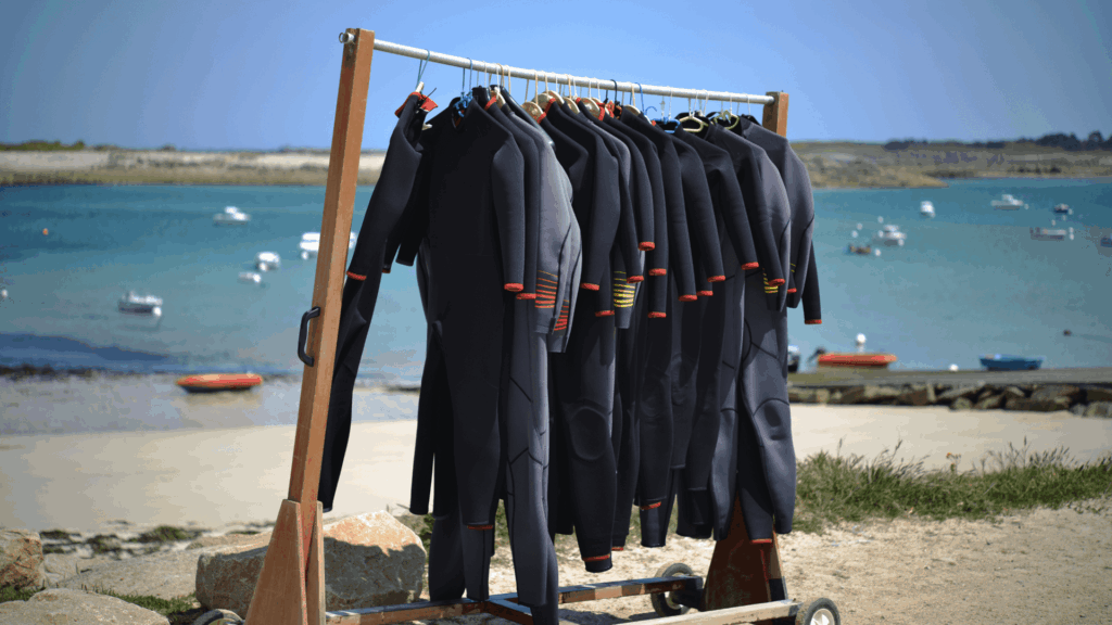 A rack of wetsuits on the beach